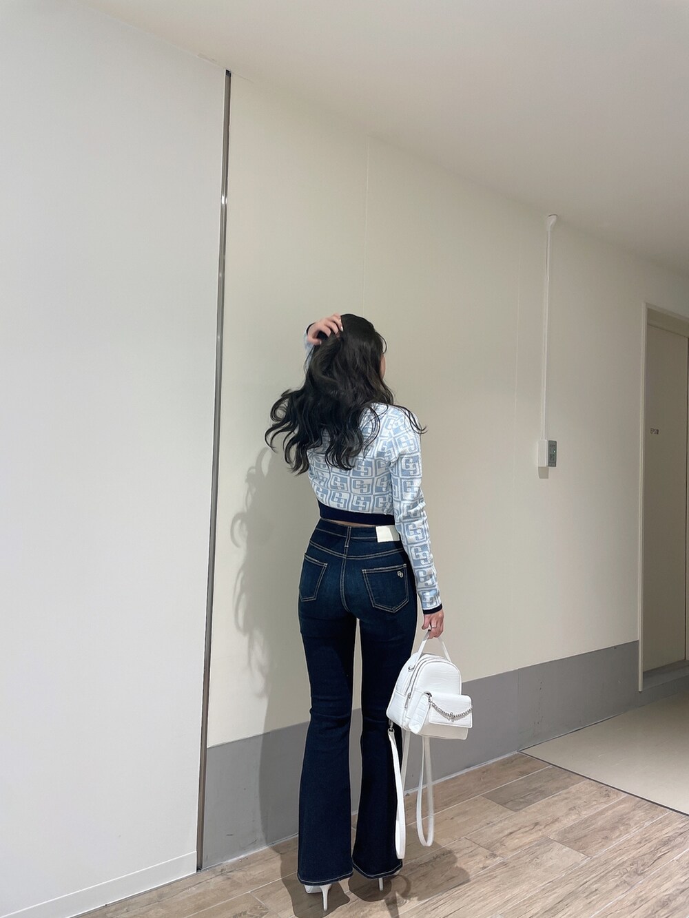 ブルー系のニット/セーター、ブルー系のカーディガン/ボレロ、ブルー系のデニムパンツを着用したレディースの春コーディネートの4枚目の写真