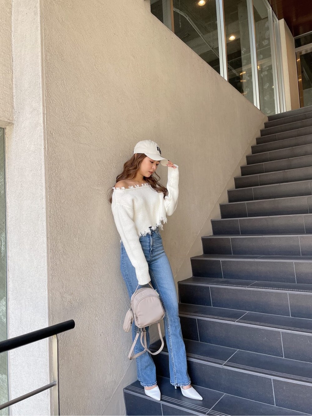 ホワイト系のニット/セーター、ホワイト系のパンプス、ブルー系のデニムパンツを着用したレディースの冬コーディネートの3枚目の写真