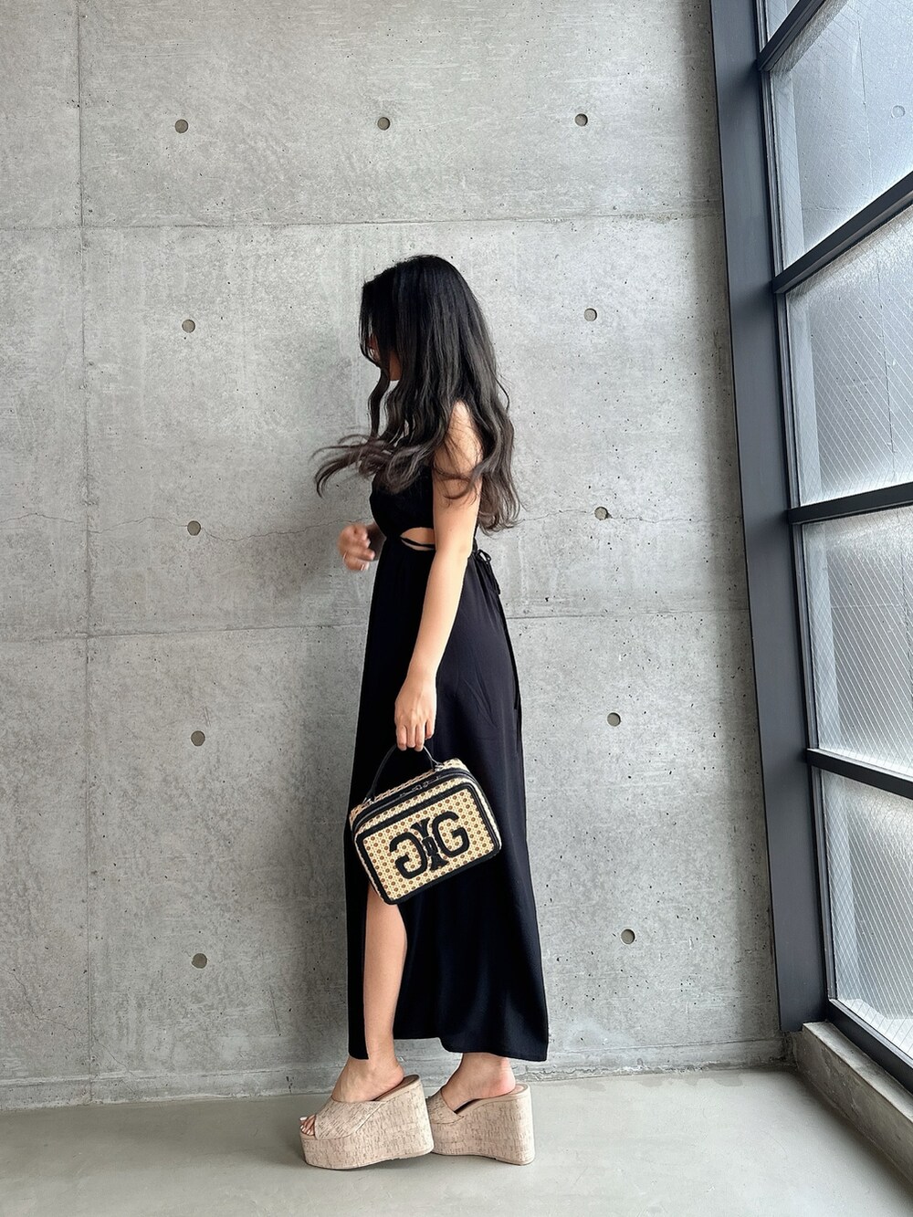 ホワイト系のサンダル、ブラック系のワンピース、ベージュ系のショルダーバッグを着用したレディースの夏コーディネートの4枚目の写真