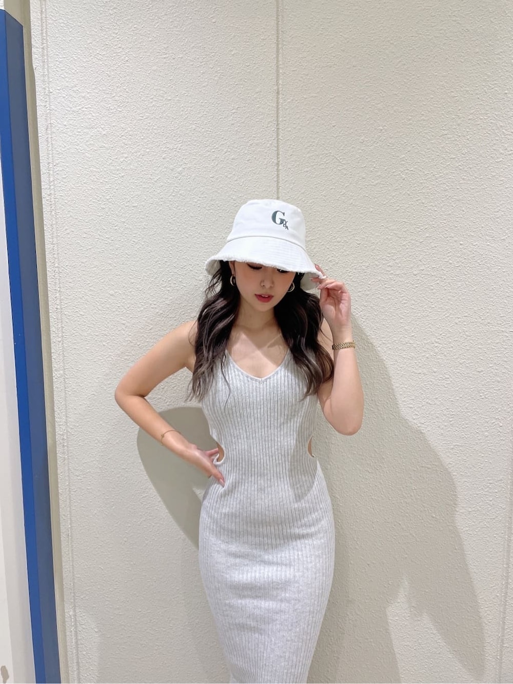 ホワイト系のサンダル、グレー系のワンピース、ホワイト系のハットを着用したレディースの夏コーディネートの4枚目の写真