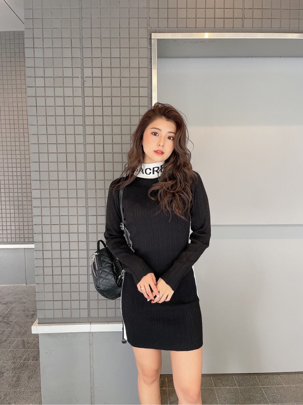 ブラック系のブーツ、ブラック系のバックパック/リュック、ブラック系のワンピースを着用したレディースの秋コーディネートの4枚目の写真