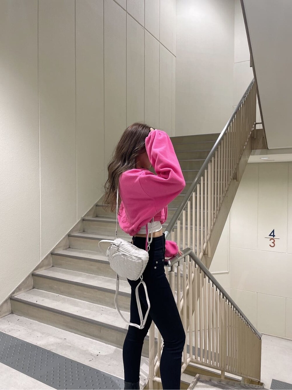 ブラック系のブーツ、ピンク系のTシャツ/カットソー、ブラック系のデニムパンツを着用したレディースの秋コーディネートの5枚目の写真