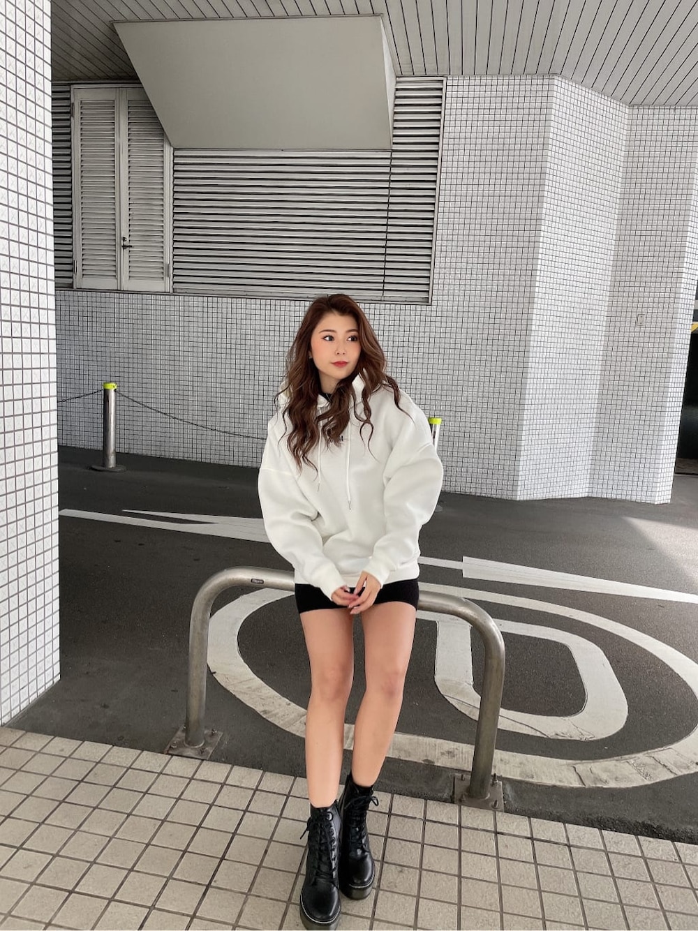 ブラック系のワンピース、ブラック系のブーツ、ホワイト系のTシャツ/カットソーを着用したレディースの冬コーディネートの2枚目の写真