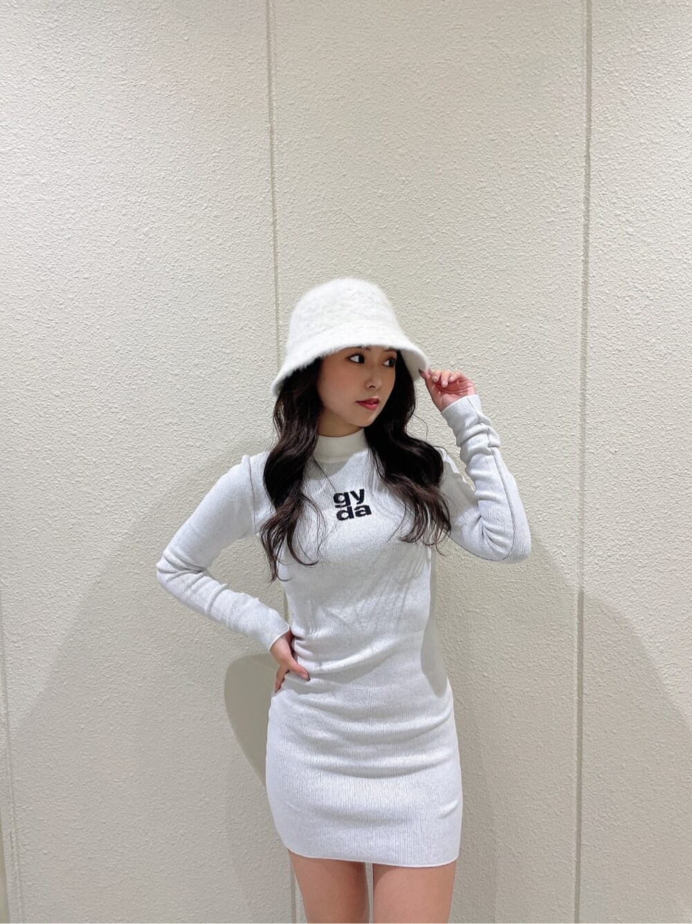 ベージュ系のスタジャン、ブラック系のブーツ、ホワイト系のワンピースを着用したレディースの秋コーディネートの8枚目の写真