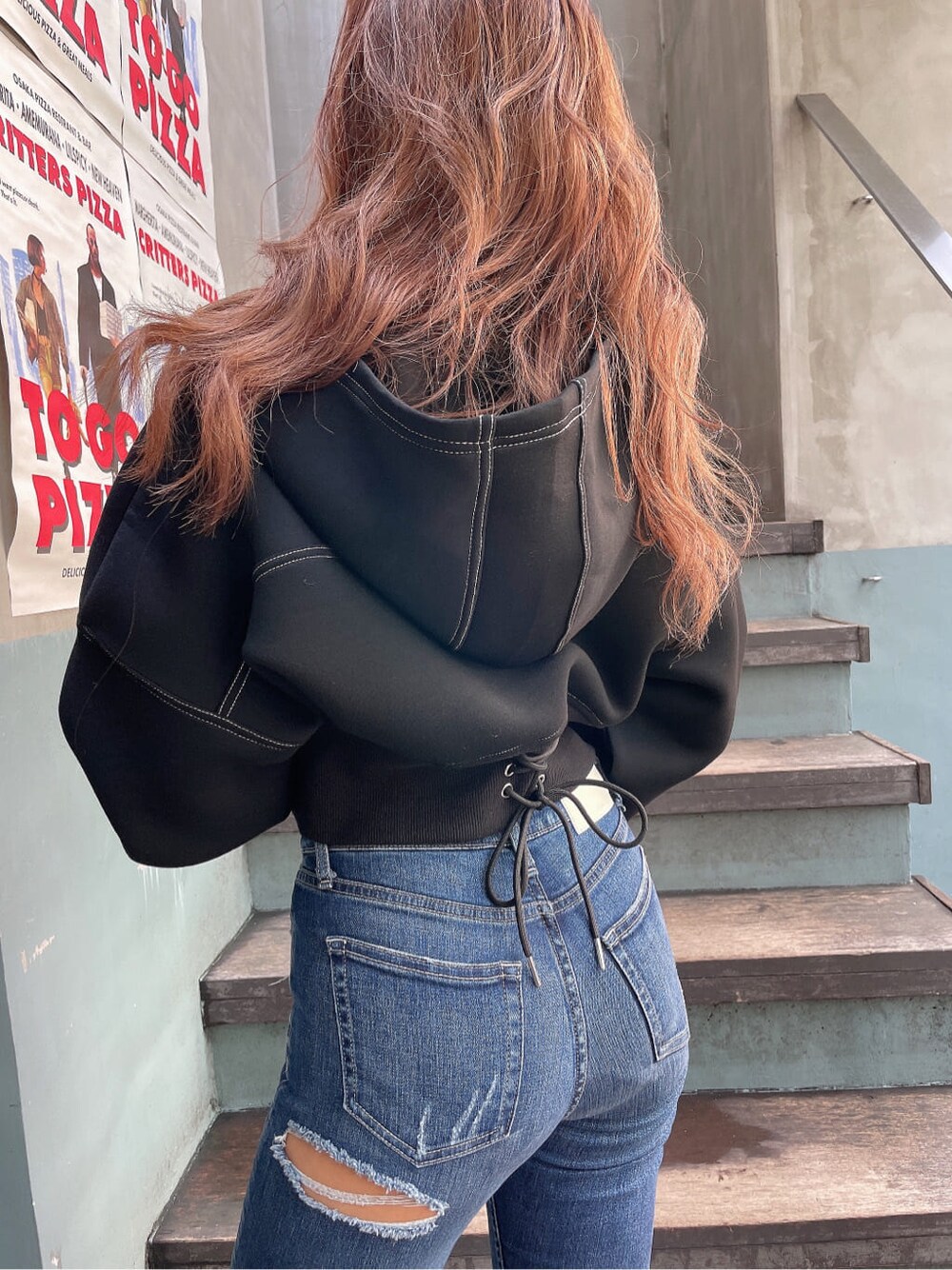 ブラック系のパンプス、ブルー系のデニムパンツ、ブラック系のパーカーを着用したレディースの秋コーディネートの7枚目の写真