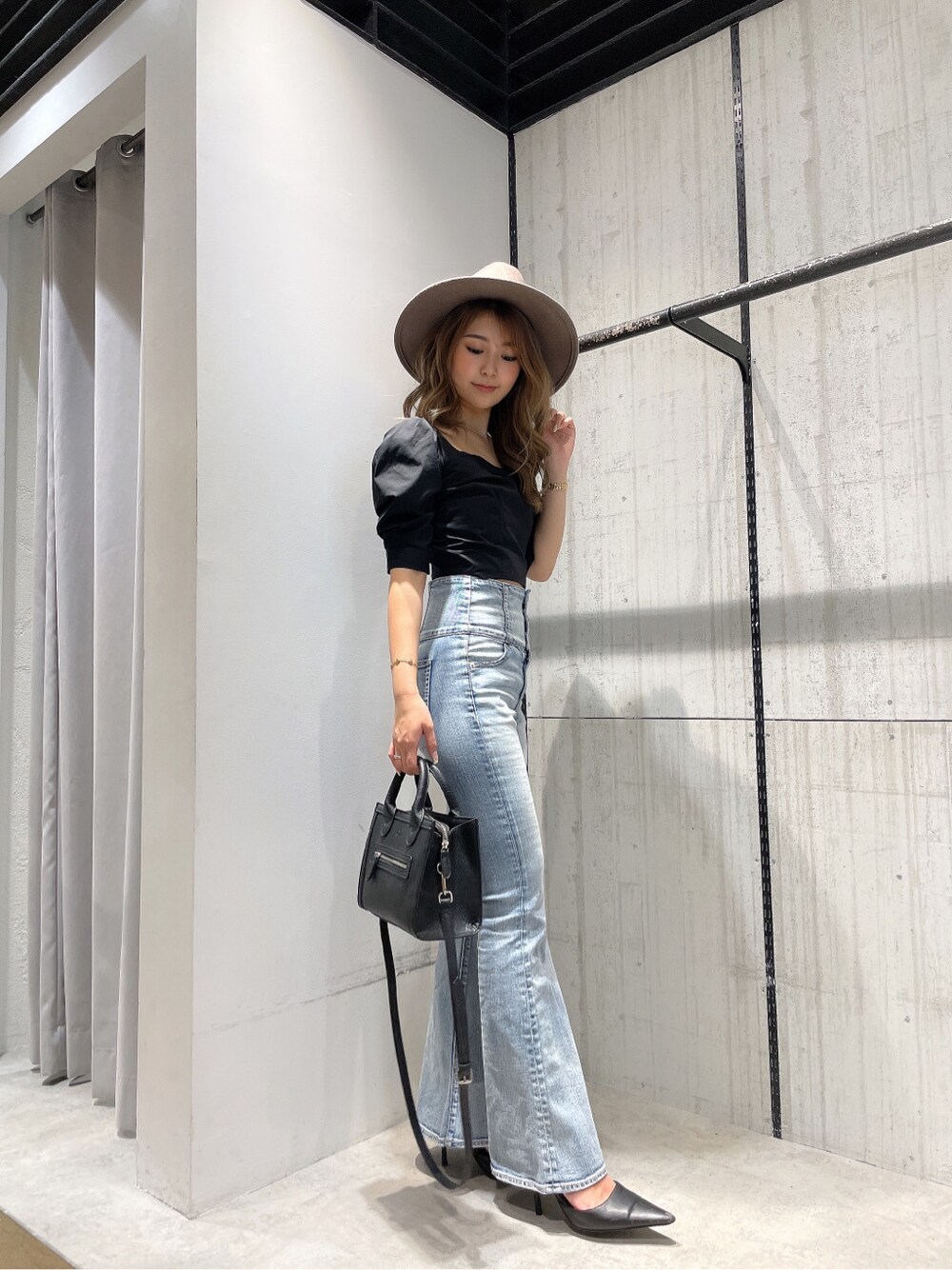 ブラック系のパンプス、ブラック系のシャツ/ブラウス、ブルー系のデニムパンツを着用したレディースの春コーディネートの2枚目の写真