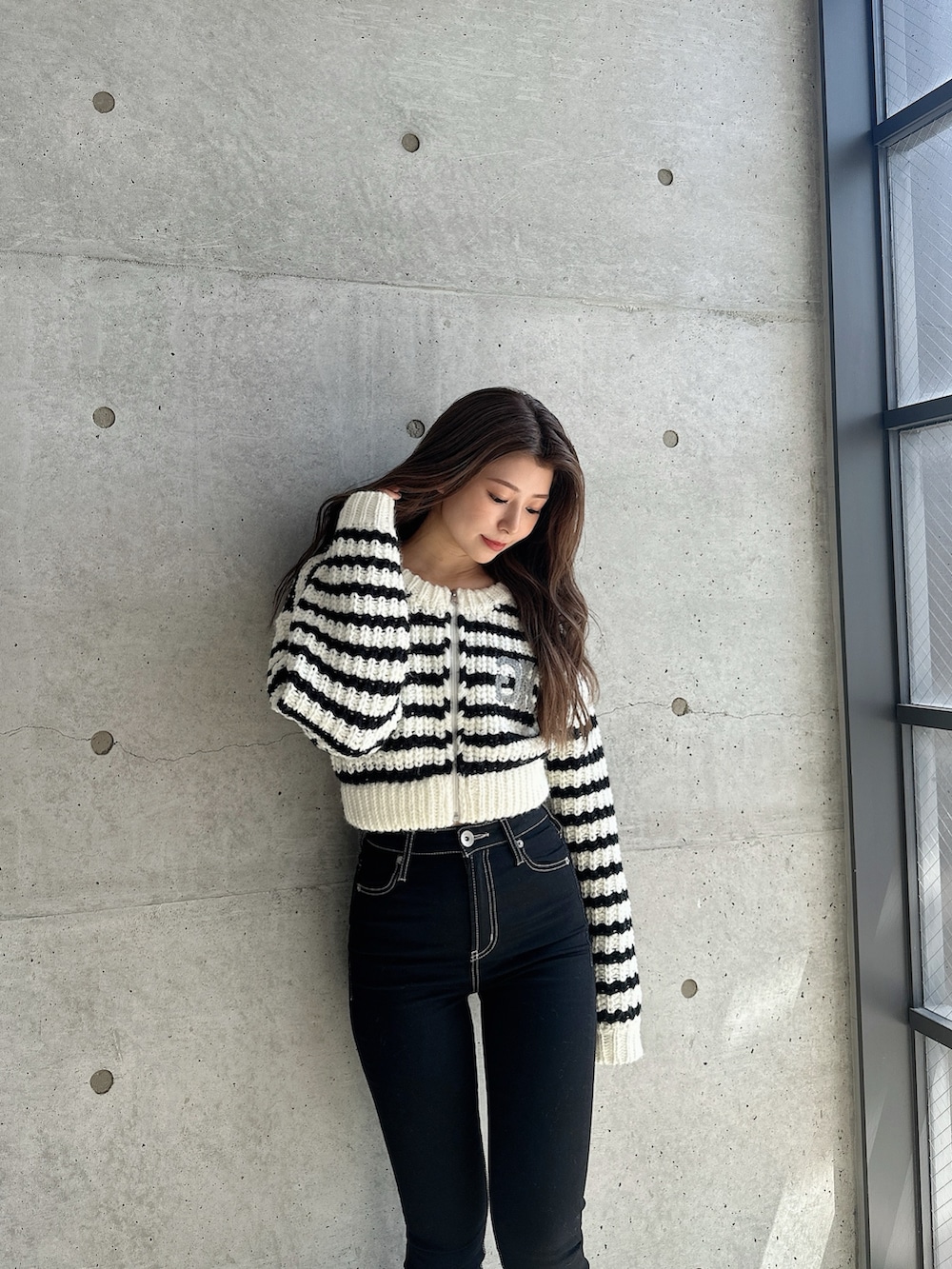 ブラック系のブーツ、ブラック系のデニムパンツ、その他のカーディガン/ボレロを着用したレディースの秋コーディネートの4枚目の写真