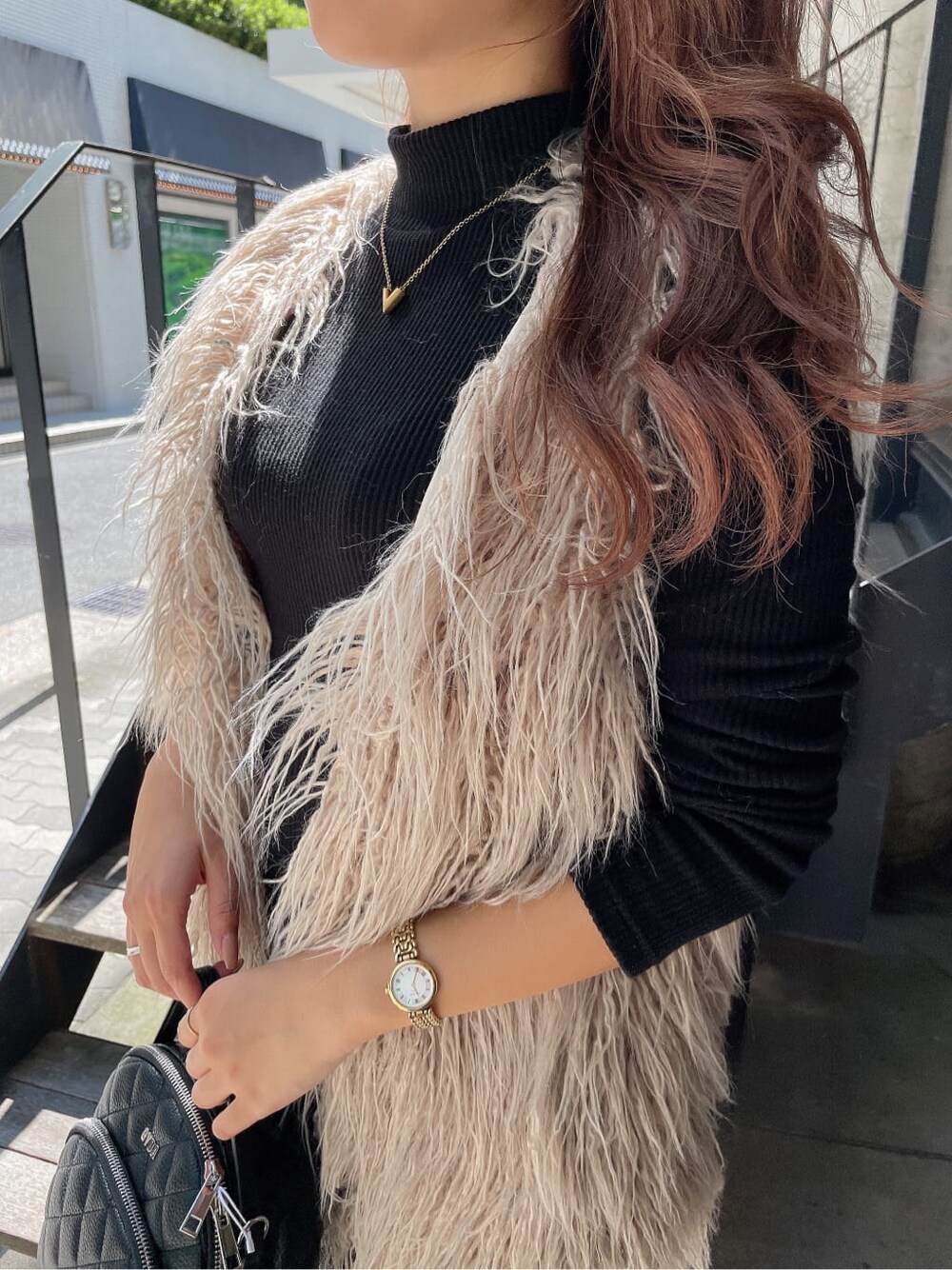 ブラック系のバックパック/リュック、ベージュ系のベスト、ブラック系のブーツを着用したレディースの秋コーディネートの8枚目の写真