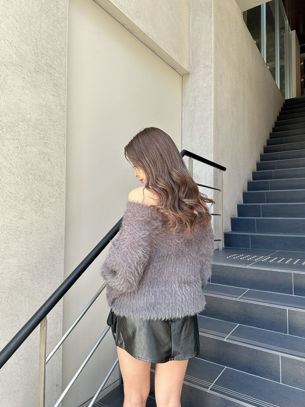 ホワイト系のニット/セーター、ブラック系のスカート、ブラック系のブーツを着用したレディースの冬コーディネートの7枚目の写真