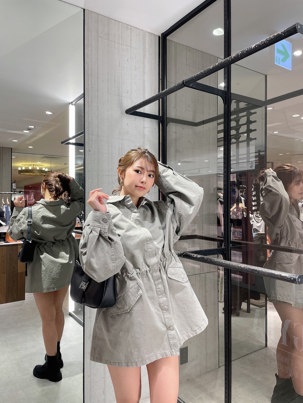 グレー系のミリタリージャケット、ホワイト系のハンドバッグ、ブラック系のブーツを着用したレディースの春コーディネートの6枚目の写真