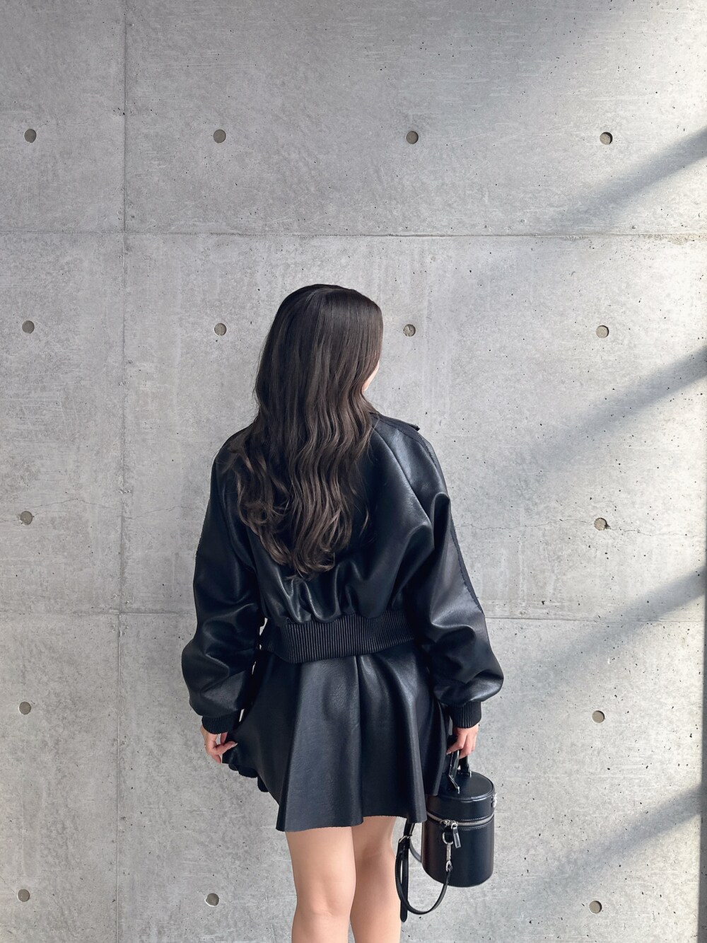 ブラック系のブーツ、ブラック系のスカート、ブラック系のブルゾンを着用したレディースの冬コーディネートの6枚目の写真