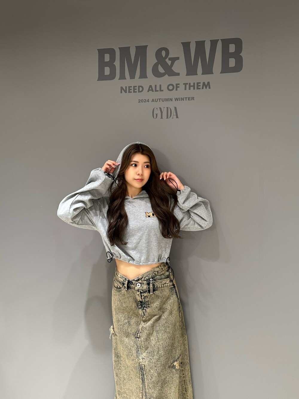 グレー系のパーカー、ブルー系のデニムスカート、ブラック系のブルゾンを着用したレディースの秋コーディネートの8枚目の写真