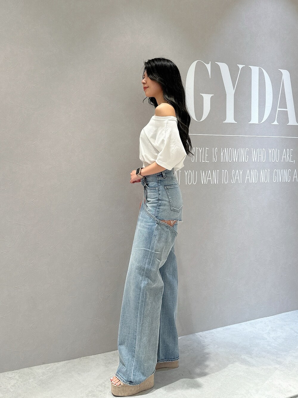 ホワイト系のサンダル、ホワイト系のTシャツ/カットソー、ブルー系のデニムパンツを着用したレディースの夏コーディネートの4枚目の写真