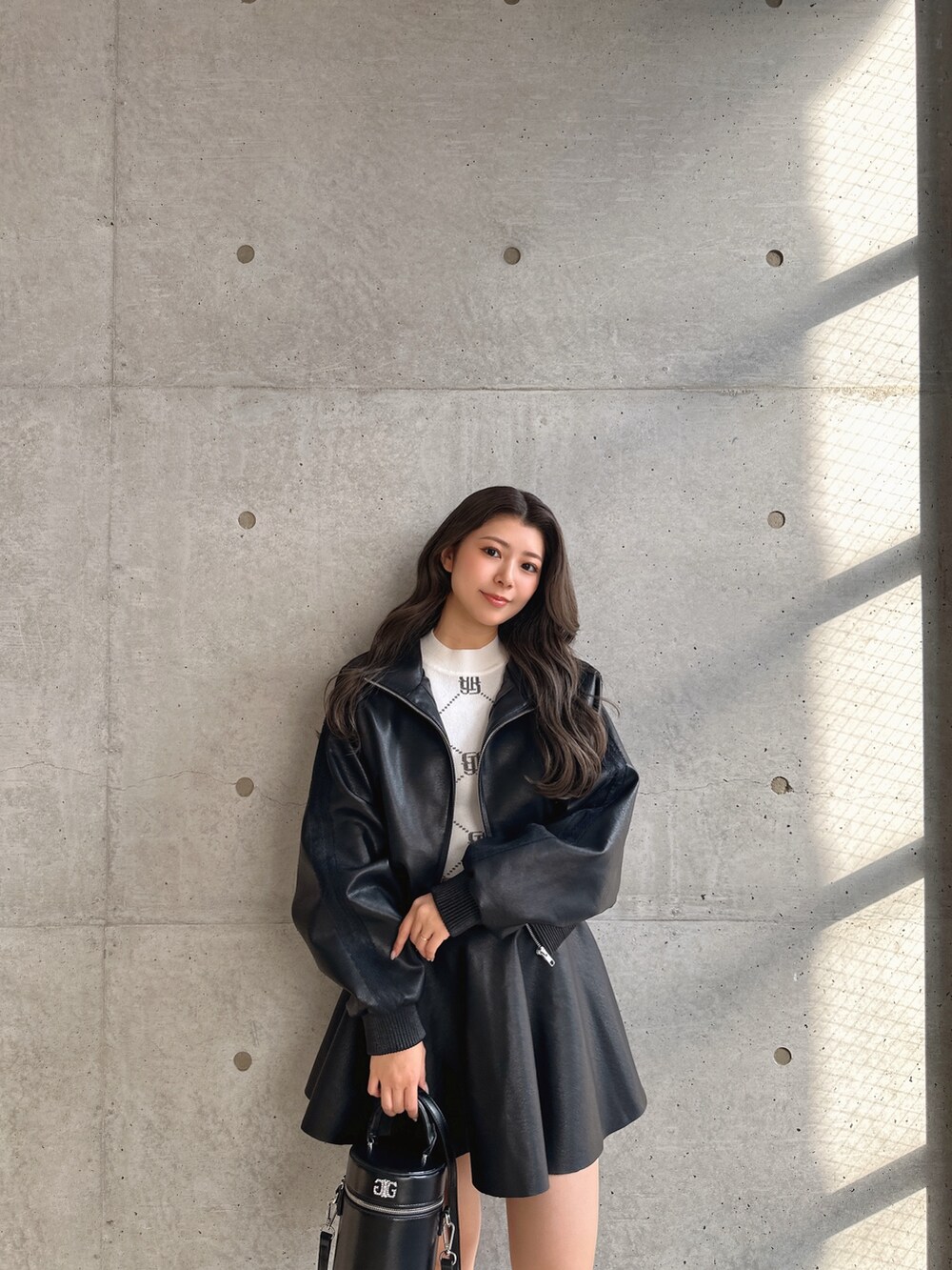 ブラック系のブーツ、ブラック系のスカート、ブラック系のブルゾンを着用したレディースの冬コーディネートの4枚目の写真