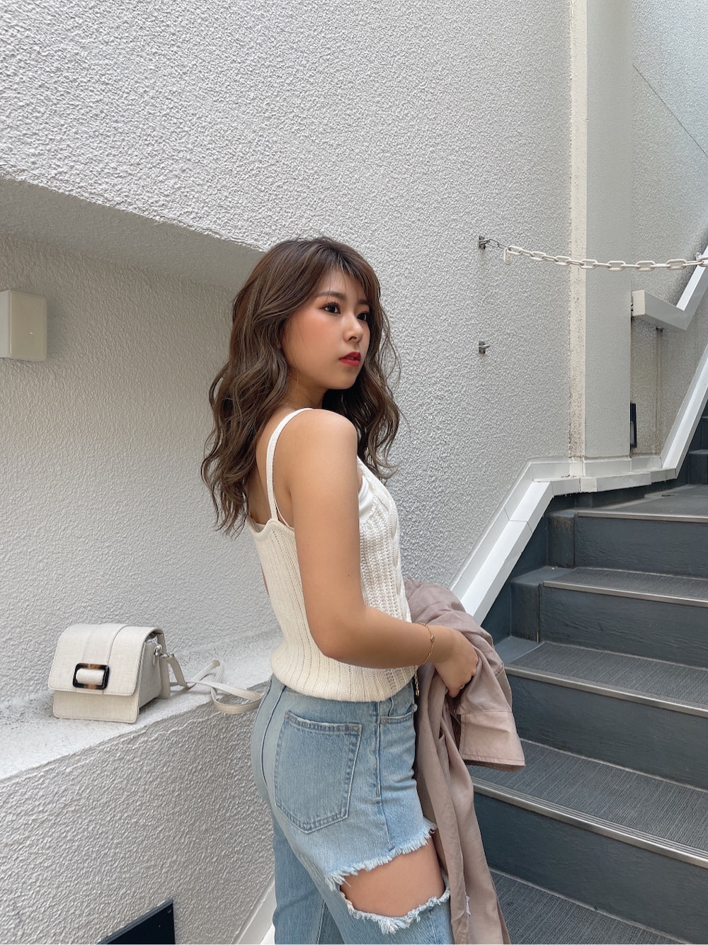 ホワイト系のキャミソール、ホワイト系のキャミソール、ブルー系のデニムパンツを着用したレディースの春コーディネートの6枚目の写真