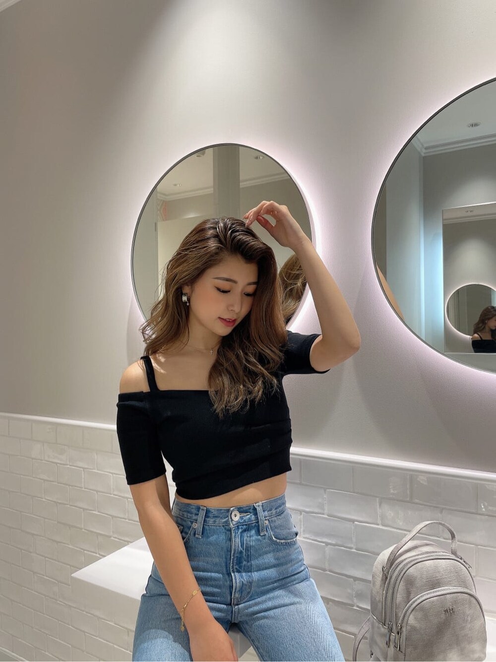 ブラック系のサンダル、ブラック系のTシャツ/カットソー、ブルー系のデニムパンツを着用したレディースの夏コーディネートの3枚目の写真