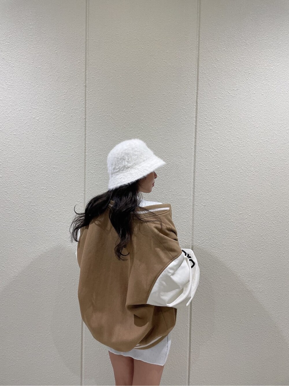 ベージュ系のスタジャン、ブラック系のブーツ、ホワイト系のワンピースを着用したレディースの秋コーディネートの7枚目の写真