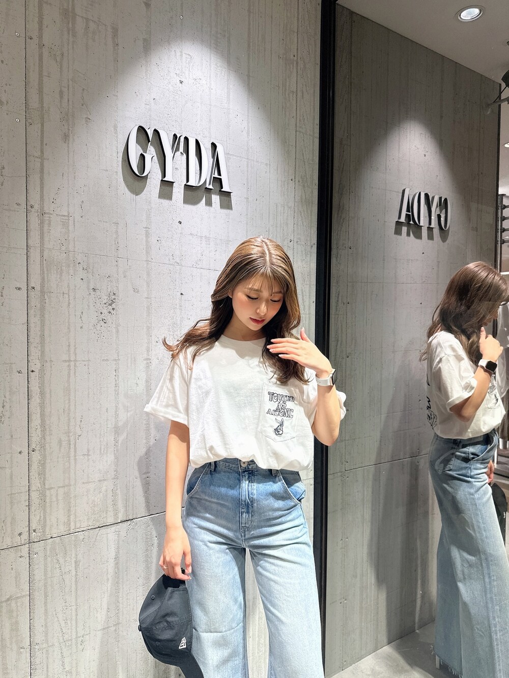 ブルー系のデニムパンツ、ホワイト系のサンダルを着用したレディースの夏コーディネートの4枚目の写真