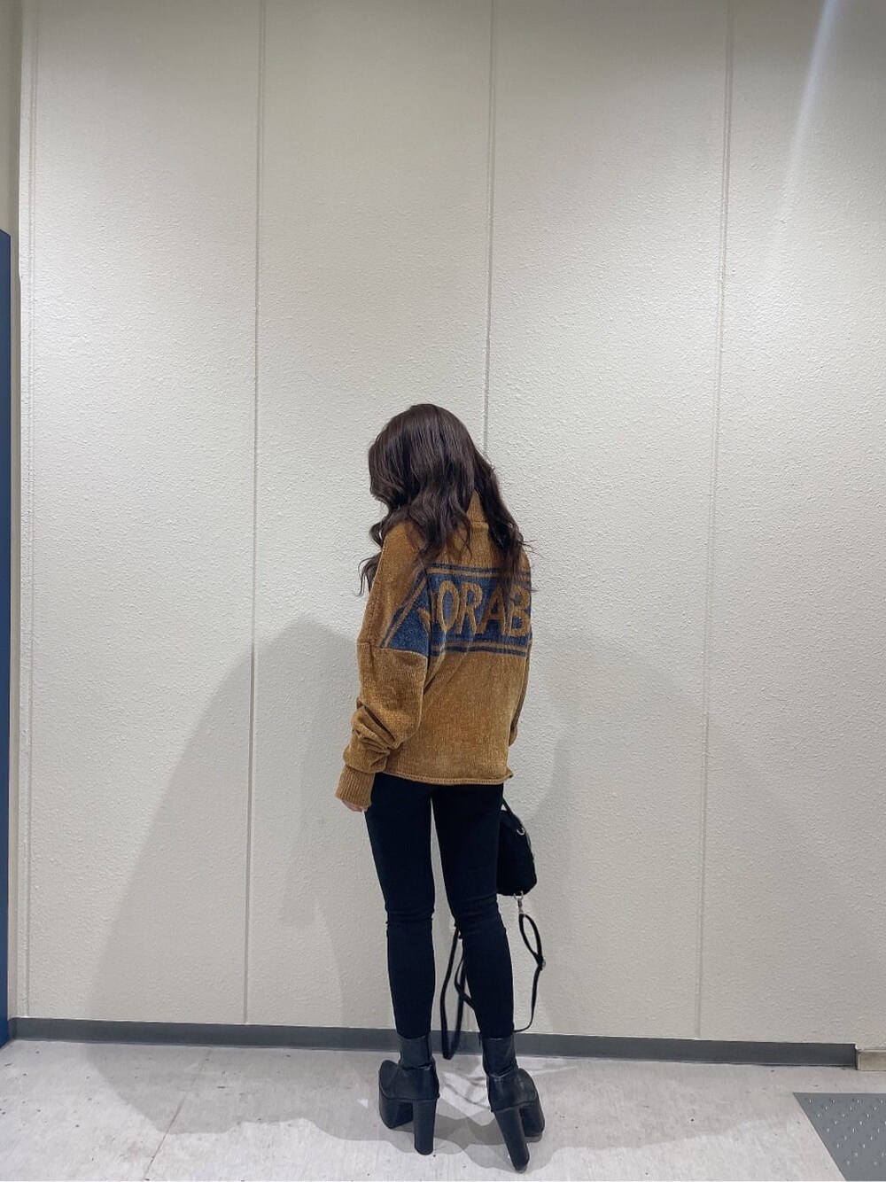 その他のデニムパンツ、ブラック系のブーツ、イエロー系のニット/セーターを着用したレディースの秋コーディネートの3枚目の写真