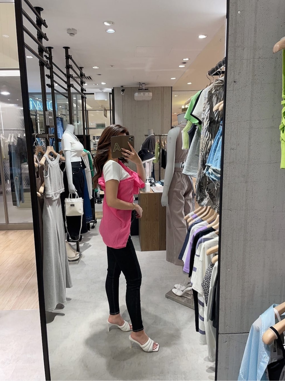 ブラック系のデニムパンツ、ホワイト系のサンダル、ホワイト系のTシャツ/カットソーを着用したレディースの夏コーディネートの2枚目の写真