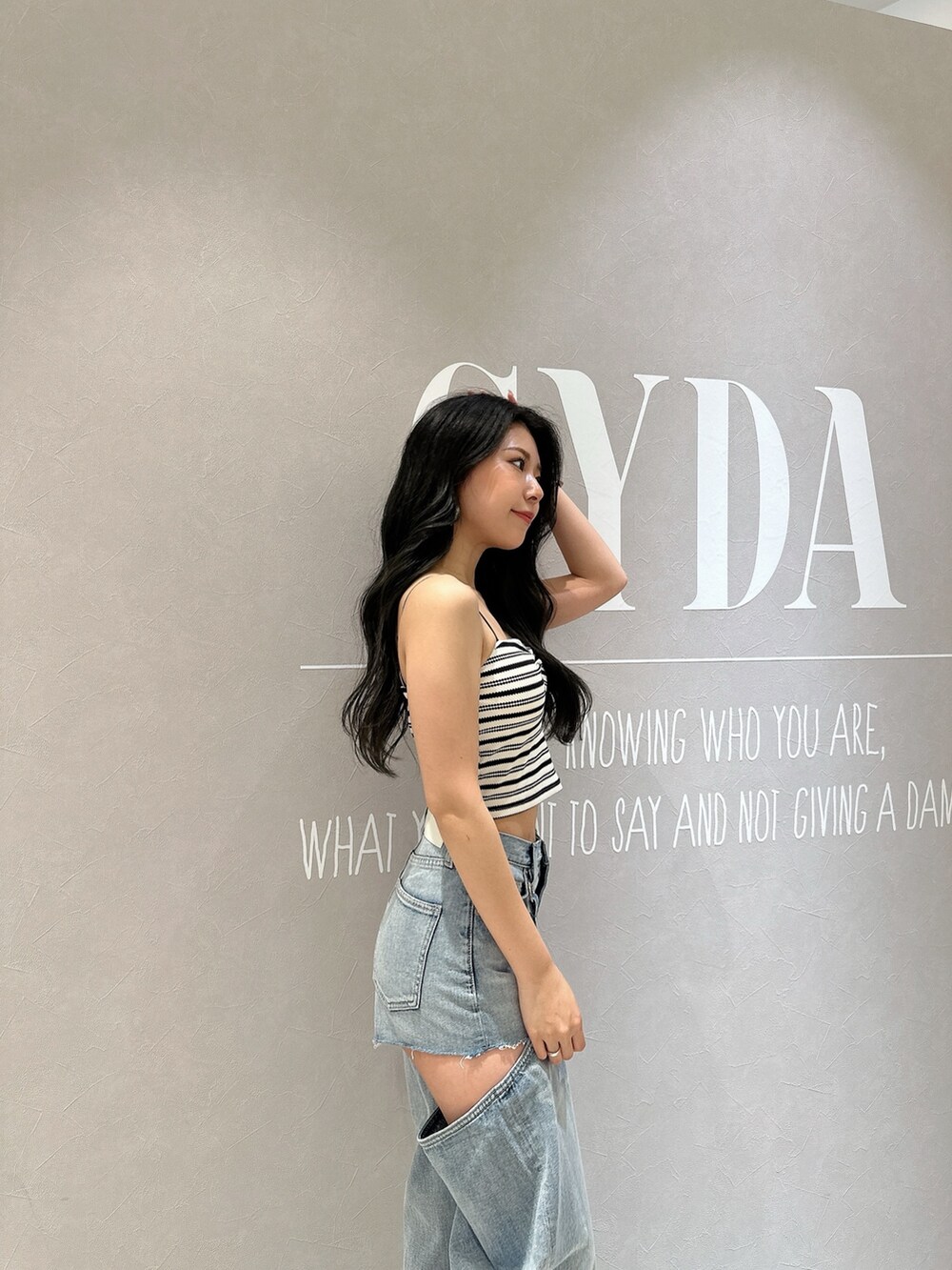 ホワイト系のキャミソール、ブルー系のデニムパンツ、ホワイト系のサンダルを着用したレディースの夏コーディネートの4枚目の写真