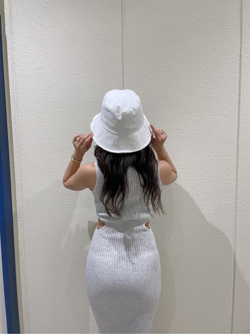 ホワイト系のサンダル、グレー系のワンピース、ホワイト系のハットを着用したレディースの夏コーディネートの6枚目の写真