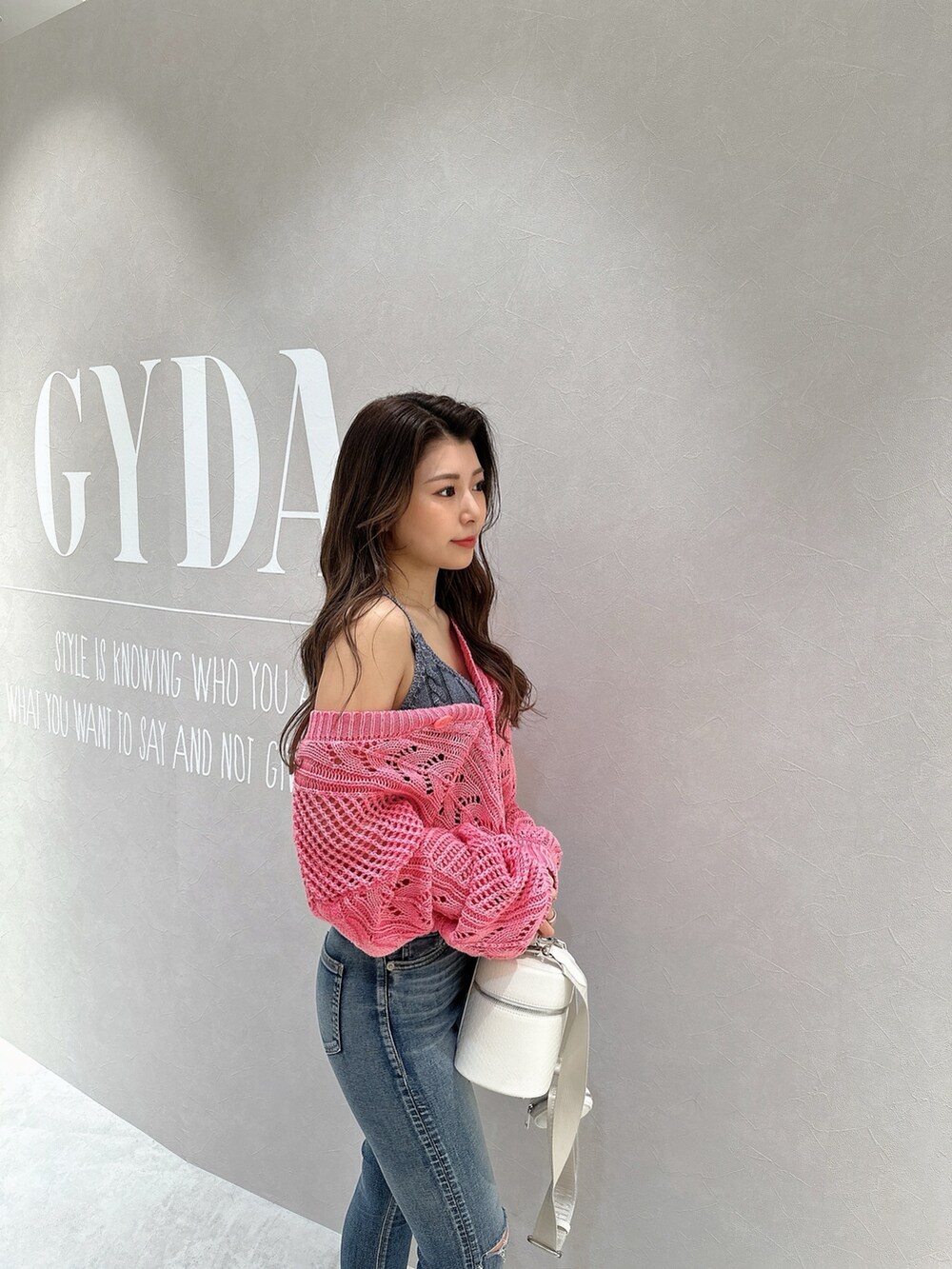 ピンク系のカーディガン/ボレロ、ブルー系のキャミソール、ホワイト系のハンドバッグを着用したレディースの春コーディネートの5枚目の写真