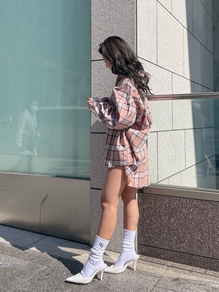 ホワイト系のパンプス、オレンジ系のシャツ/ブラウス、ブルー系のデニムパンツを着用したレディースの春コーディネートの4枚目の写真