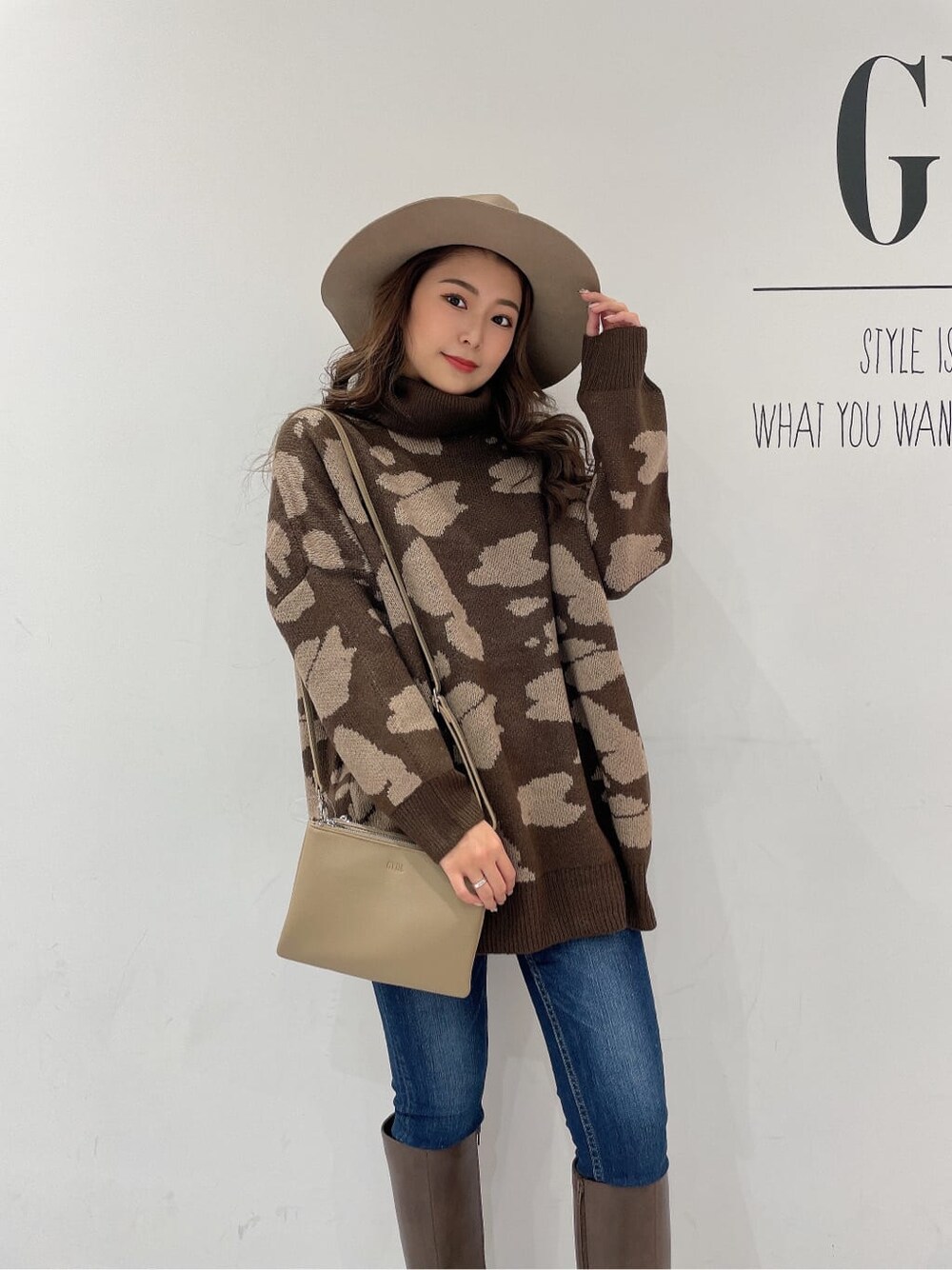 ブラウン系のブーツ、ブルー系のデニムパンツ、ベージュ系のショルダーバッグを着用したレディースの秋コーディネートの5枚目の写真