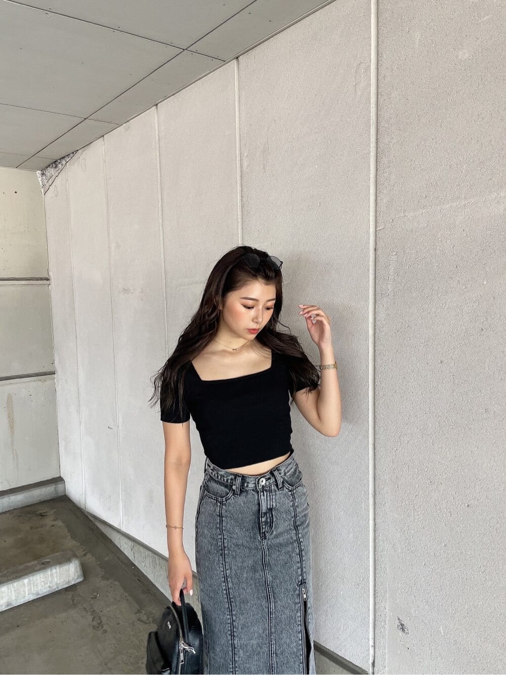 ブラック系のサンダル、ブラック系のバックパック/リュック、ブラック系のデニムスカートを着用したレディースの夏コーディネートの5枚目の写真