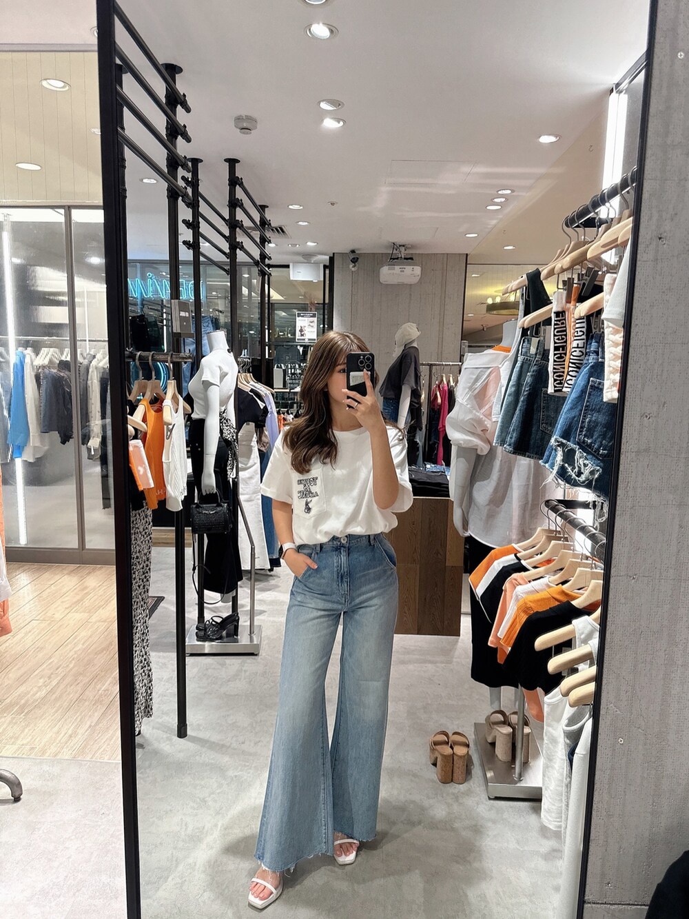 ブルー系のデニムパンツ、ホワイト系のサンダルを着用したレディースの夏コーディネートの9枚目の写真