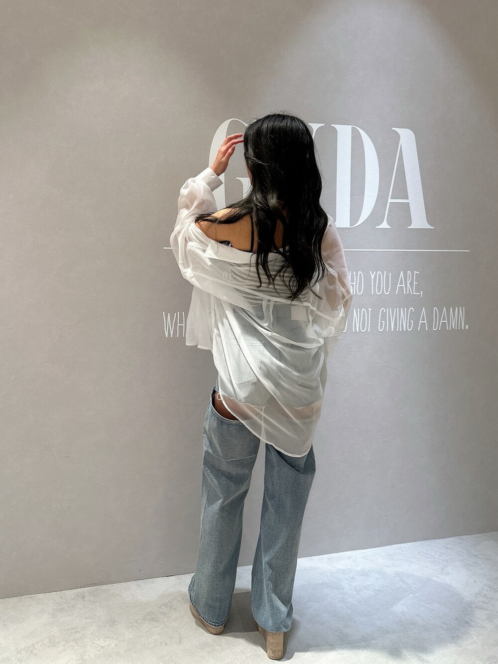 ホワイト系のキャミソール、ブルー系のデニムパンツ、ホワイト系のサンダルを着用したレディースの夏コーディネートの7枚目の写真