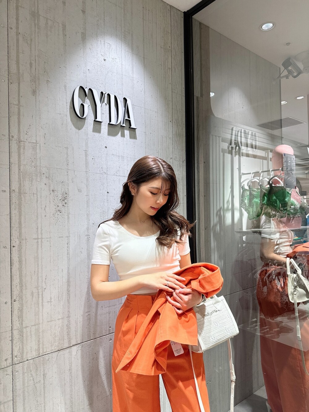 ホワイト系のTシャツ/カットソー、オレンジ系のテーラードジャケット、オレンジ系のスラックスを着用したレディースの春コーディネートの6枚目の写真