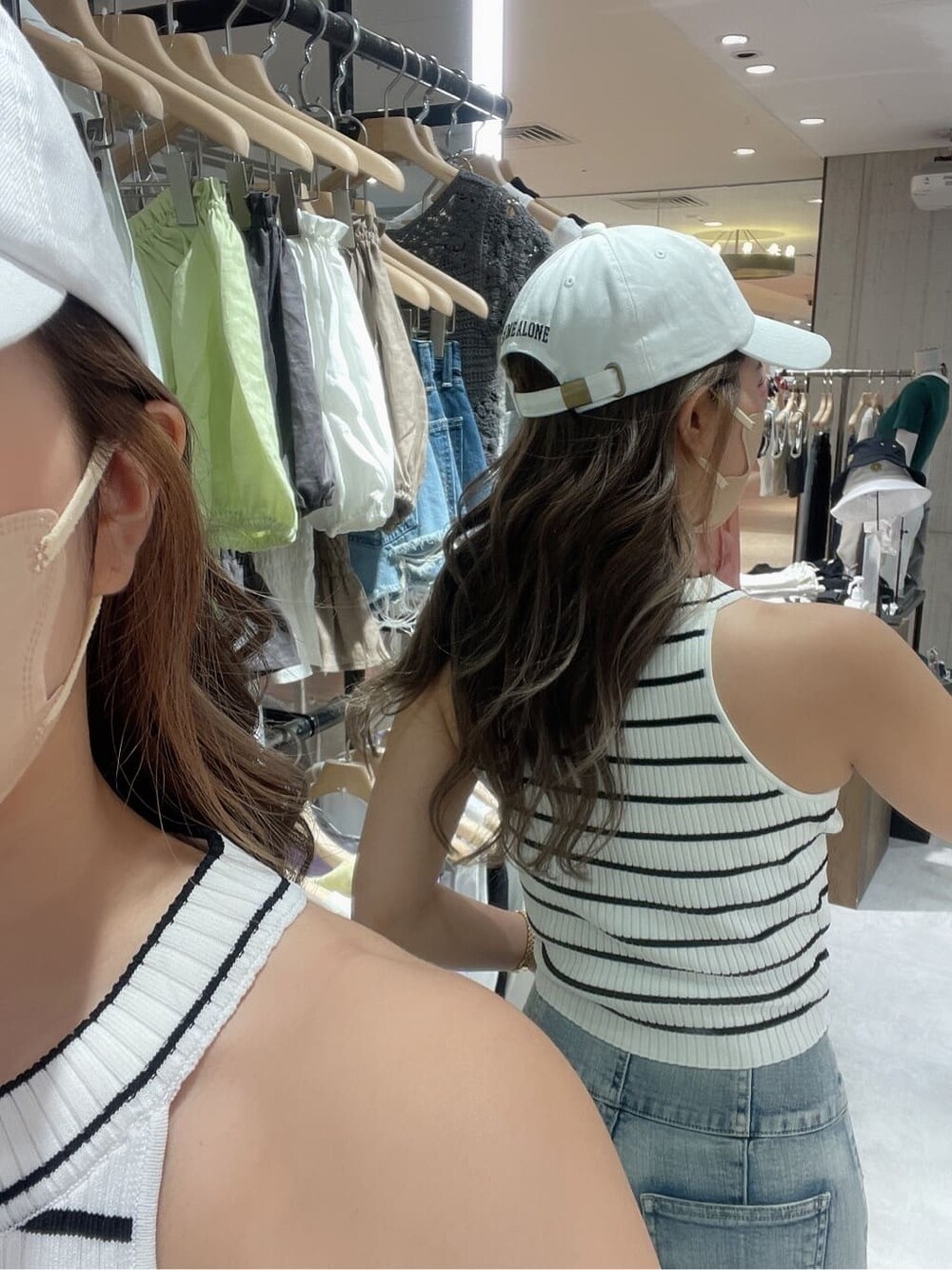 ホワイト系のサンダル、ホワイト系のタンクトップ、ブルー系のデニムパンツを着用したレディースの夏コーディネートの6枚目の写真