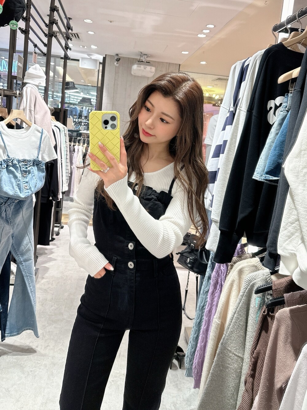 ブラック系のサロペット/オーバーオール、ホワイト系のニット/セーター、ブラック系のパンプスを着用したレディースの春コーディネートの3枚目の写真