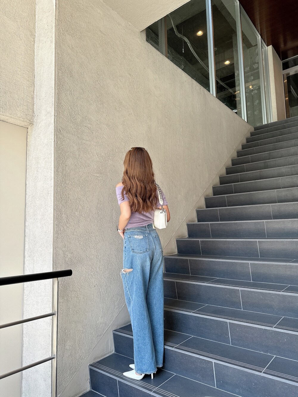 ブラック系のパンプス、パープル系のニット/セーター、ホワイト系のハンドバッグを着用したレディースの夏コーディネートの3枚目の写真