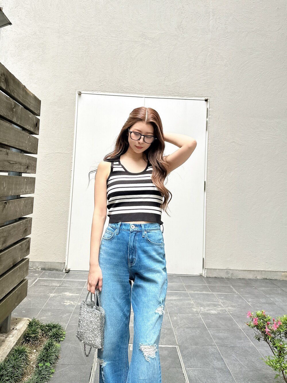 ブルー系のデニムパンツ、ホワイト系のパンプス、ホワイト系のニット/セーターを着用したレディースの夏コーディネートの5枚目の写真