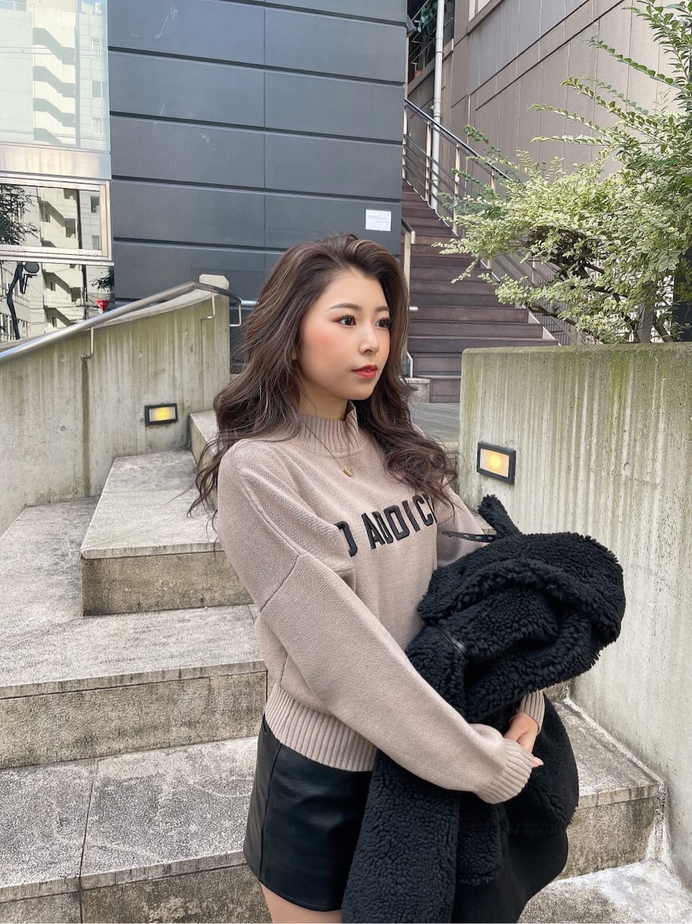 ベージュ系のニット/セーター、ブラック系のスカート、ブラウン系のブルゾンを着用したレディースの冬コーディネートの5枚目の写真