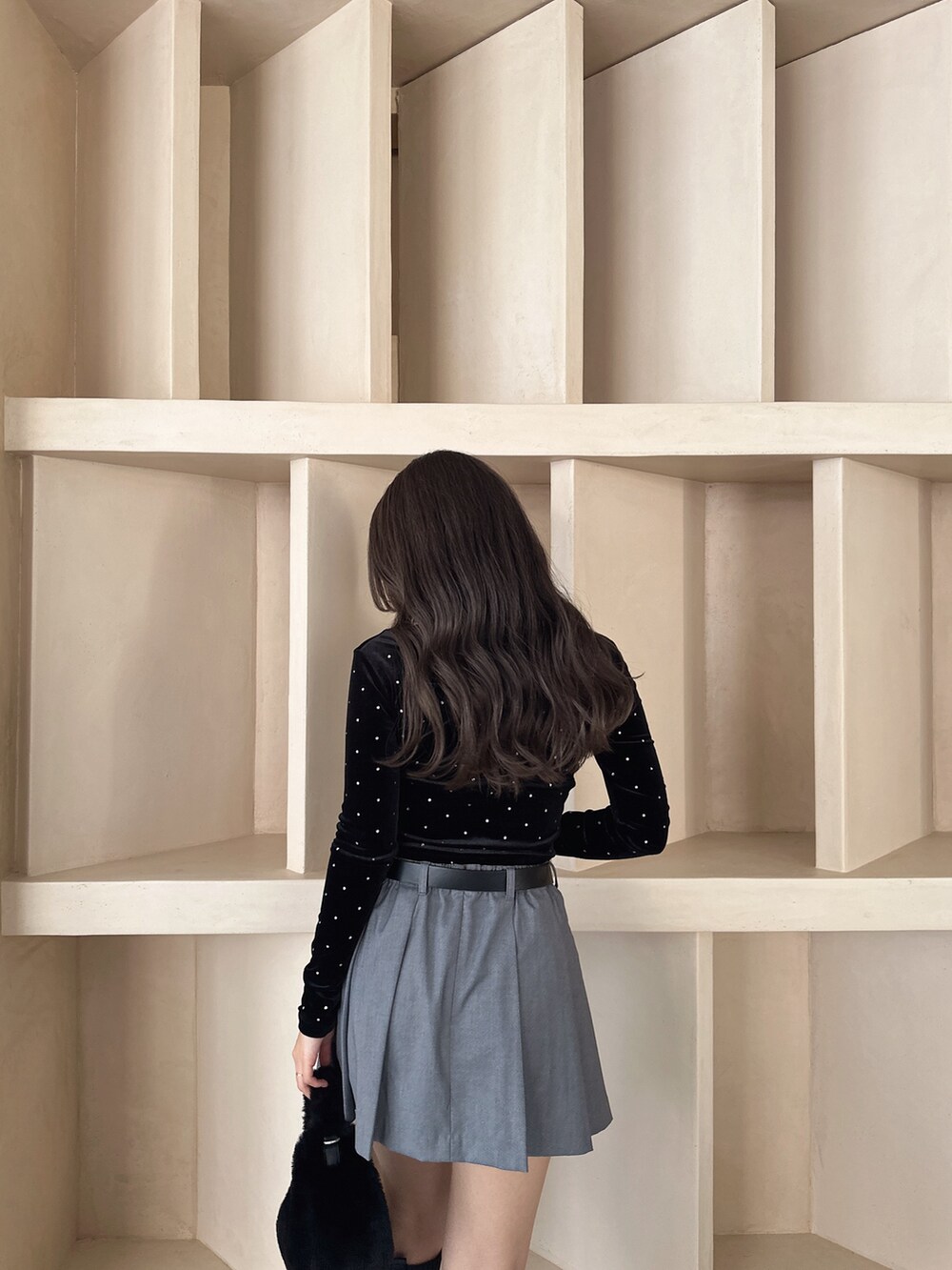 ブラック系のブーツ、ブラック系のTシャツ/カットソー、グレー系のスカートを着用したレディースの秋コーディネートの5枚目の写真