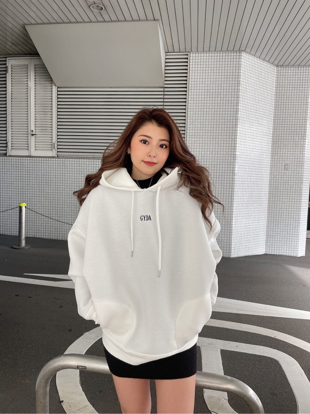 ブラック系のワンピース、ブラック系のブーツ、ホワイト系のTシャツ/カットソーを着用したレディースの冬コーディネートの3枚目の写真