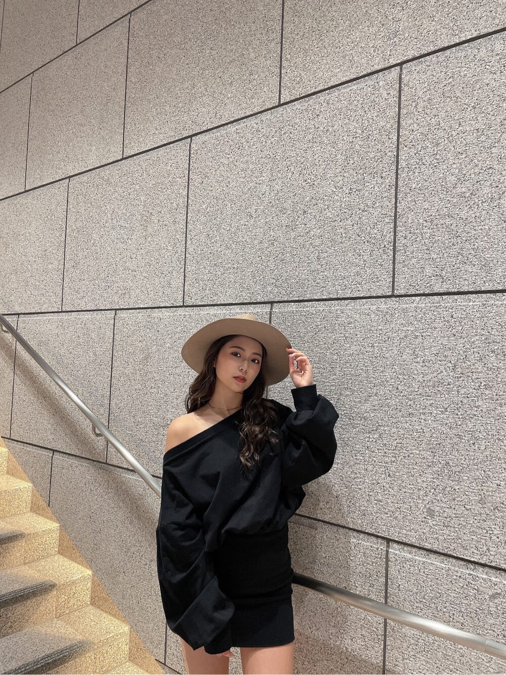 ブラック系のワンピース、ブラック系のブーツ、ベージュ系のハットを着用したレディースの秋コーディネートの6枚目の写真