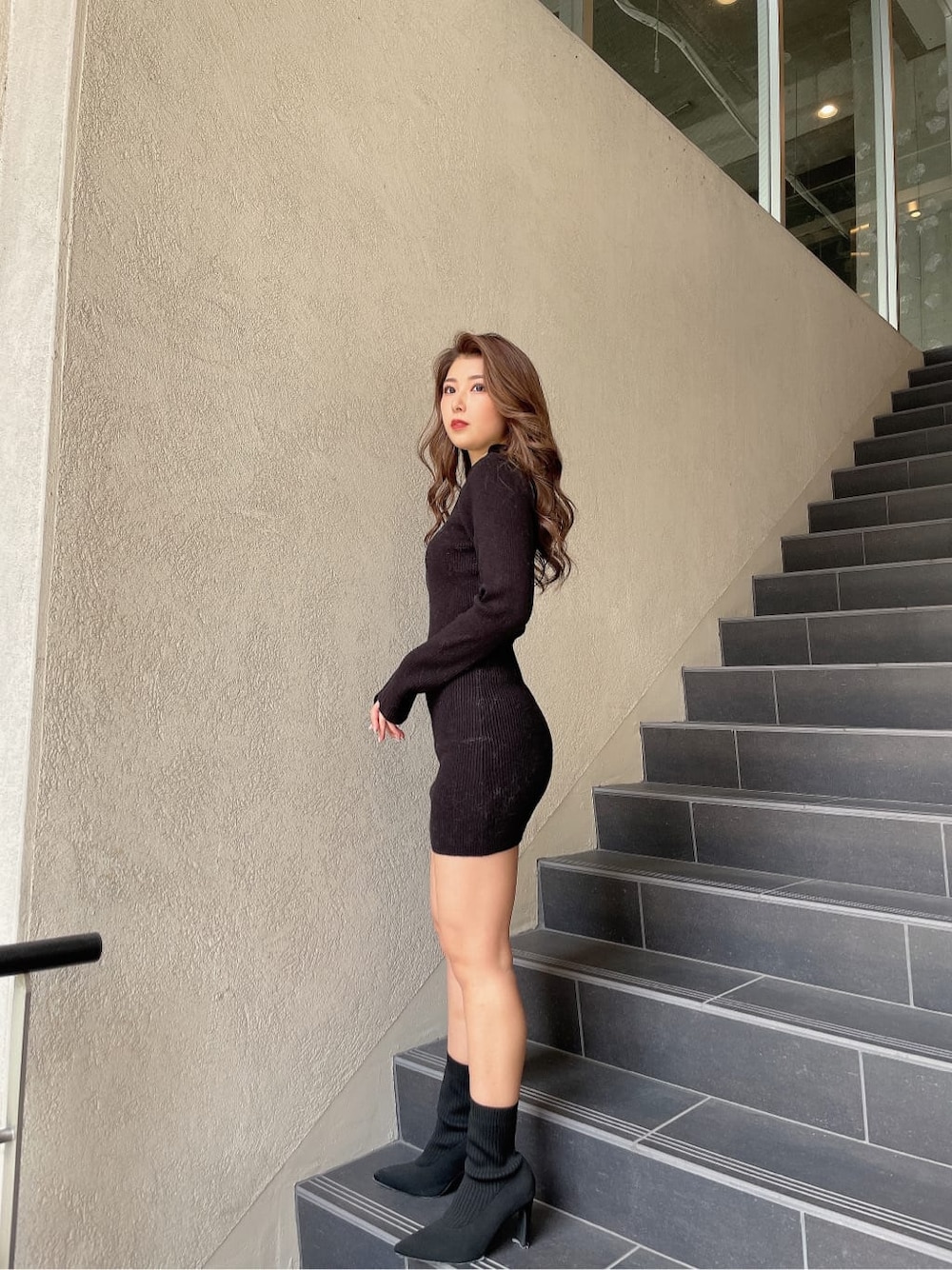 ブラック系のブーツ、ブラック系のワンピースを着用したレディースの冬コーディネートの2枚目の写真