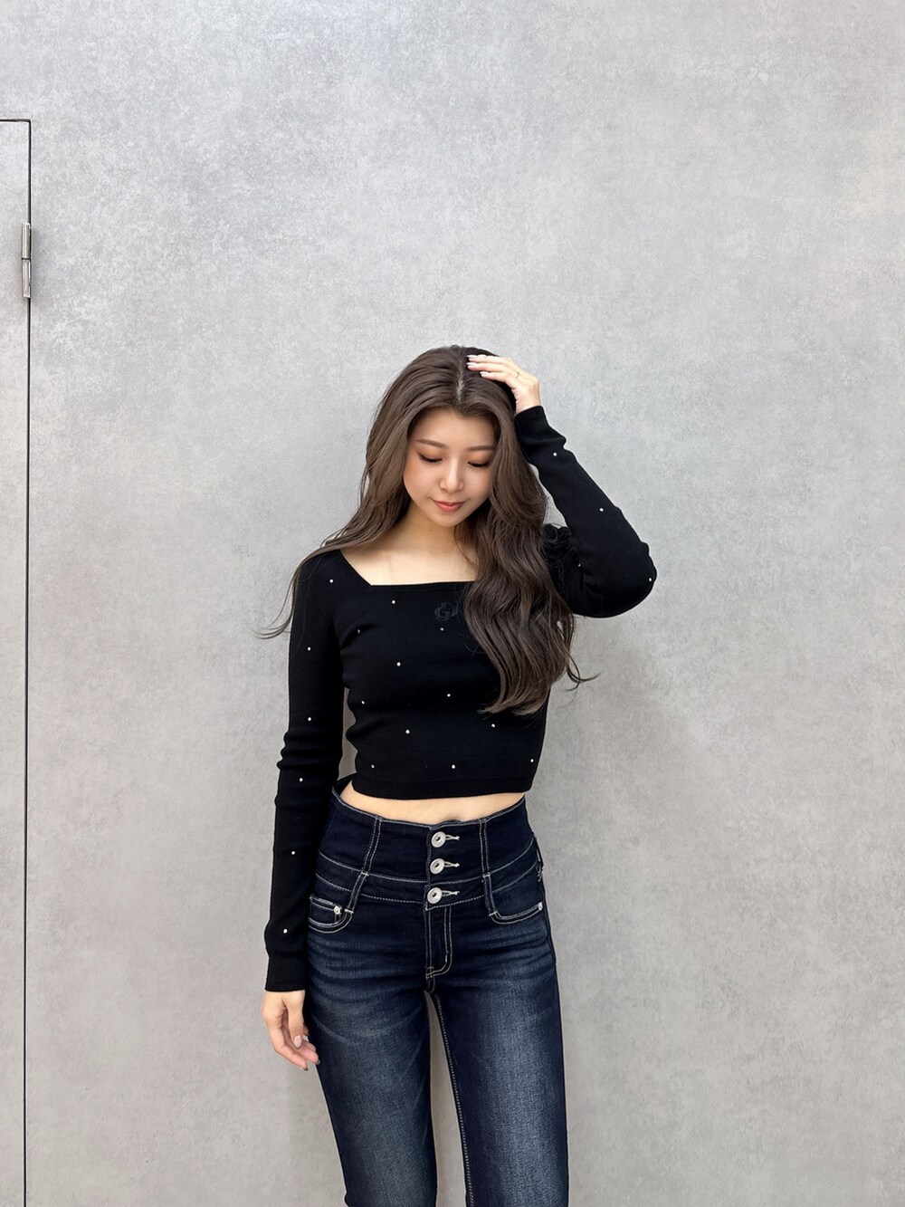 ブルー系のデニムパンツ、ブラック系のブーツ、ブラック系のニット/セーターを着用したレディースの冬コーディネートの5枚目の写真