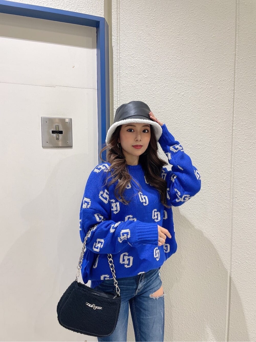 ブルー系のデニムパンツ、ブルー系のデニムパンツ、ブラック系のブーツを着用したレディースの秋コーディネートの5枚目の写真