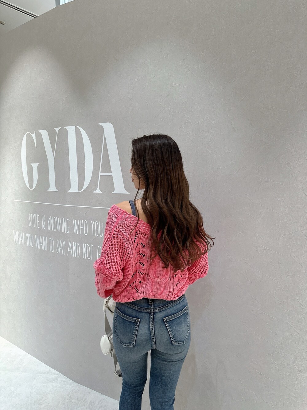 ピンク系のカーディガン/ボレロ、ブルー系のキャミソール、ホワイト系のハンドバッグを着用したレディースの春コーディネートの6枚目の写真