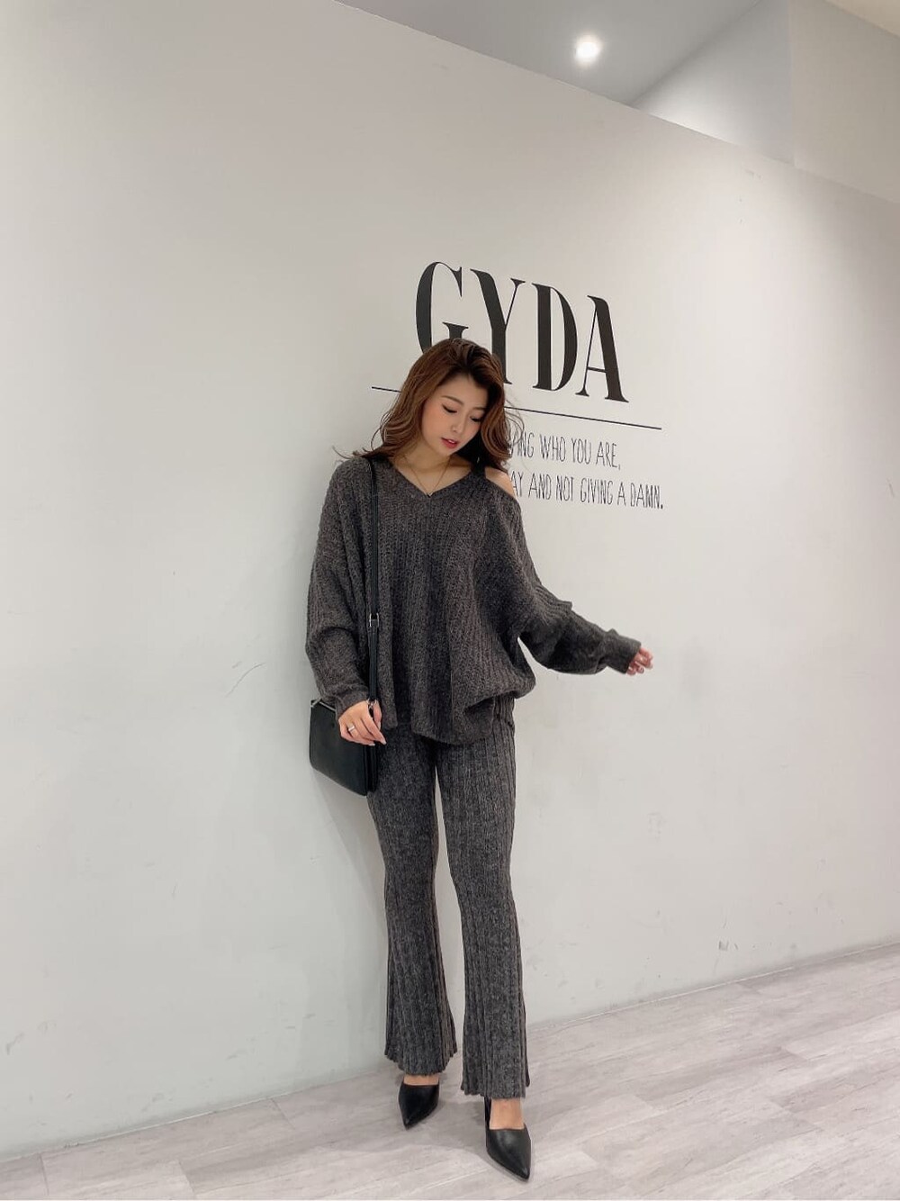 ブラック系のパンプス、グレー系のその他パンツ、ブラック系のショルダーバッグを着用したレディースの秋コーディネートの4枚目の写真