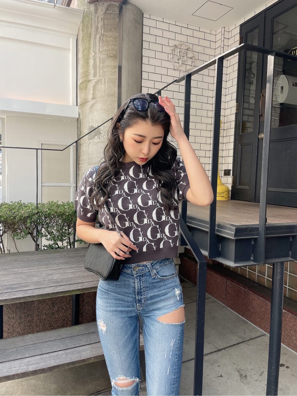 ブルー系のデニムパンツ、ホワイト系のパンプス、グレー系のニット/セーターを着用したレディースの冬コーディネートの5枚目の写真