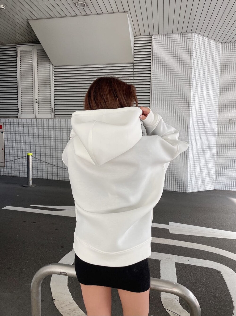 ブラック系のワンピース、ブラック系のブーツ、ホワイト系のTシャツ/カットソーを着用したレディースの冬コーディネートの6枚目の写真