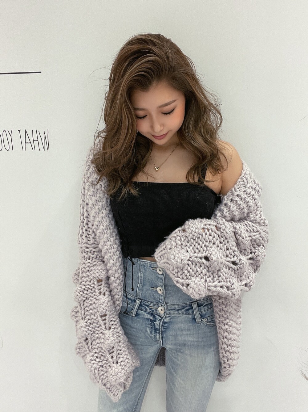 ホワイト系のパンプス、ブルー系のデニムパンツ、ブラック系のキャミソールを着用したレディースの冬コーディネートの3枚目の写真