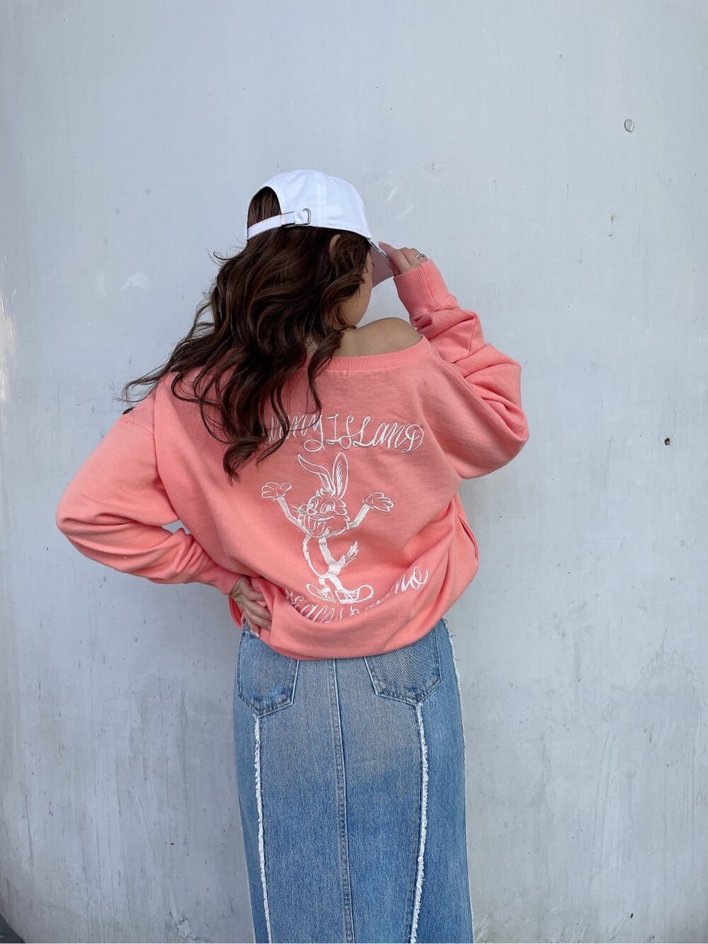 ホワイト系のブーツ、オレンジ系のスウェット、ブルー系のデニムスカートを着用したレディースの冬コーディネートの6枚目の写真